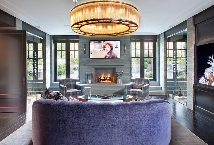 Adam Hunter designed a lounge with a purple sofa, large chandelier, and a built-in fish tank wall.