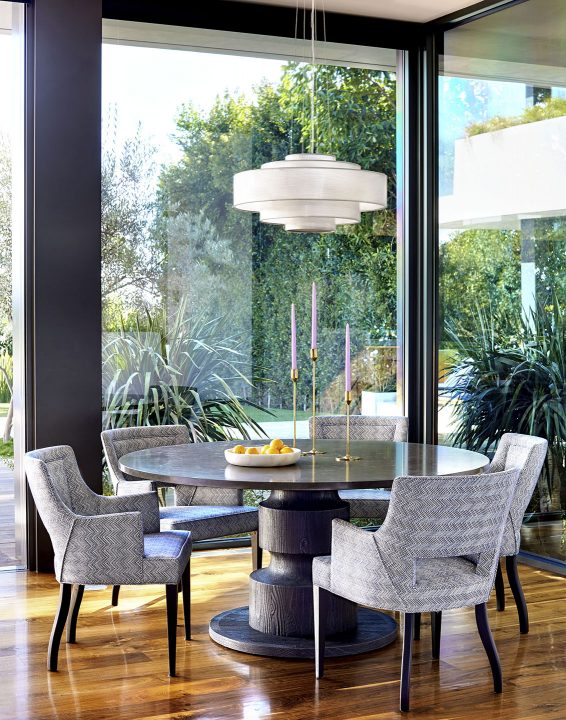 Adam hunter designed breakfast room with an Ochre chandelier and 5 armchairs with purple fabric.