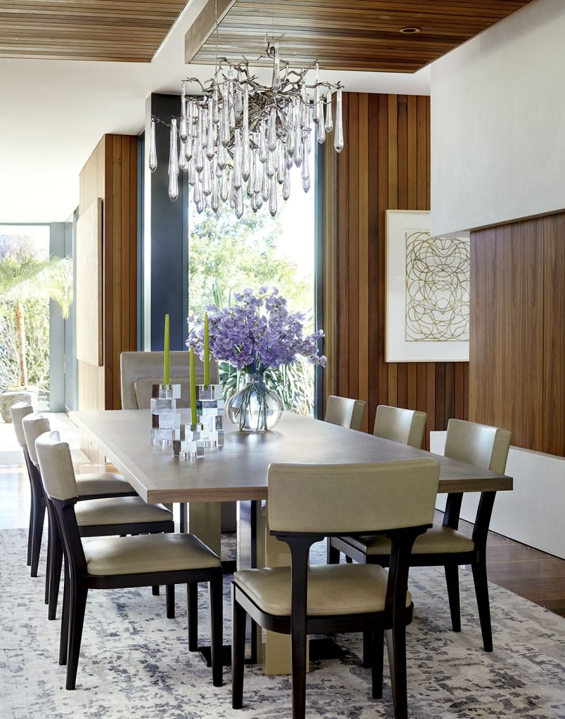 Adam Hunter designed dining room with purple flowers and large dripping chandelier.