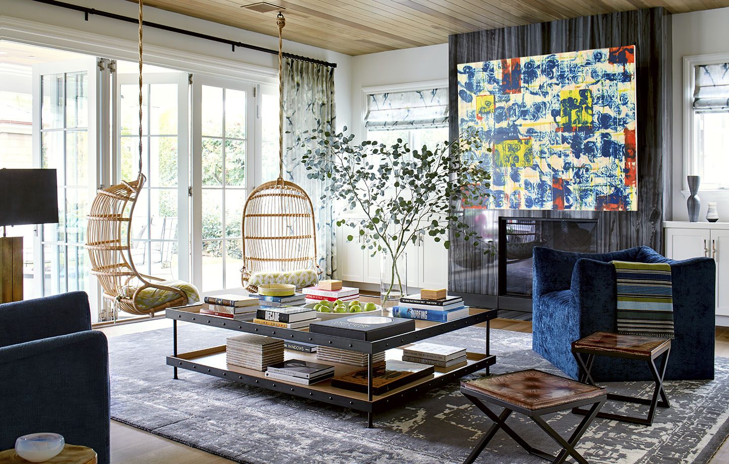 Adam Hunter designed family room with wicker hanging chairs and a grey rug.