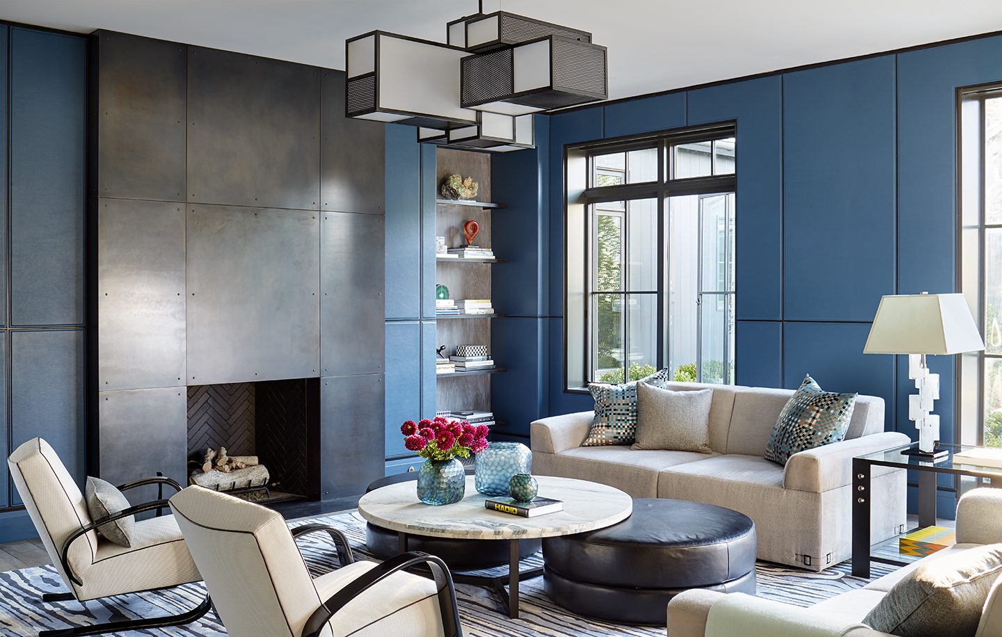 Adam hunter designed a leather room of blue and white with a chandelier.
