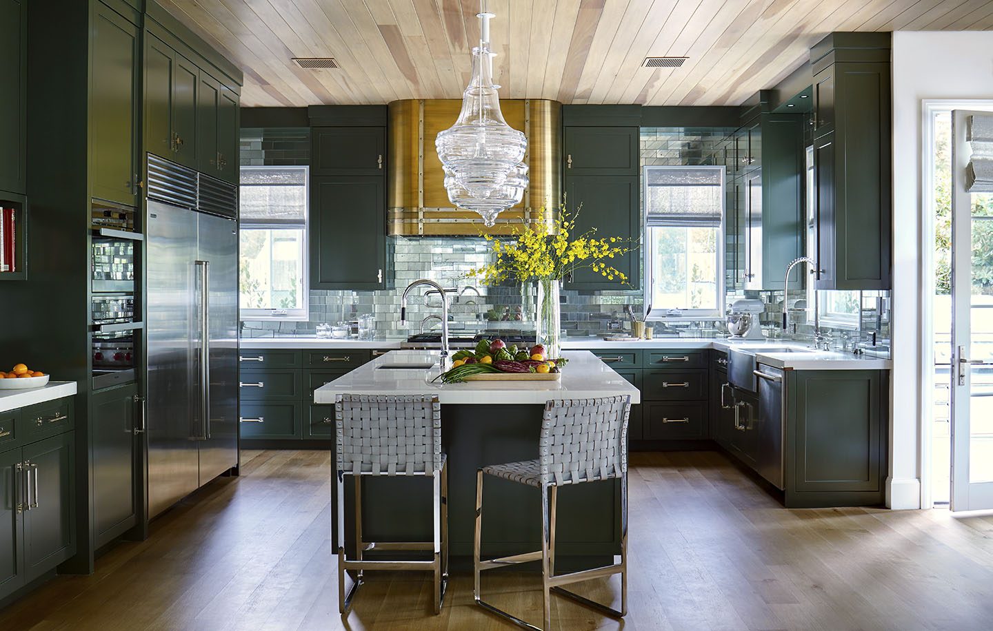 Adam Hunter designed a green kitchen with clear pendants.