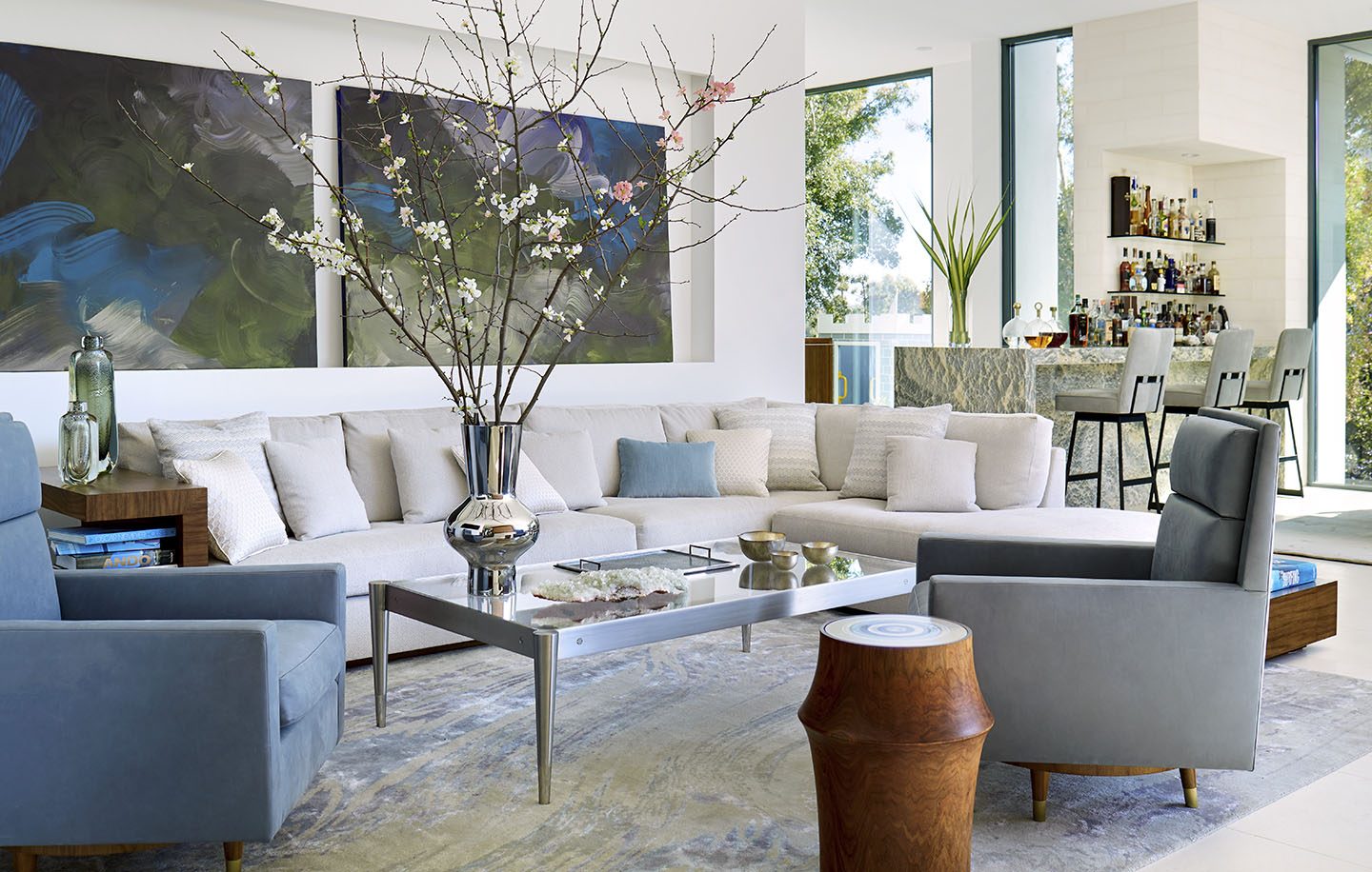 Adam Hunter designed living room with light colored sectional and two blue swivel chairs.