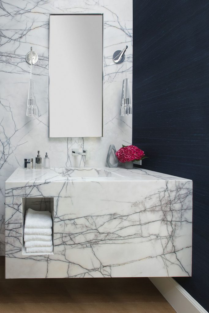 Adam Hunter designed powder room with eggplant purple wallpaper and a marble counter / wall.
