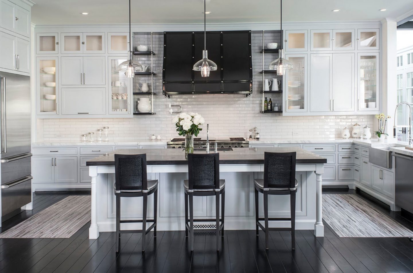 Adam hunter designed kitchen with three stools and three pendant lights.
